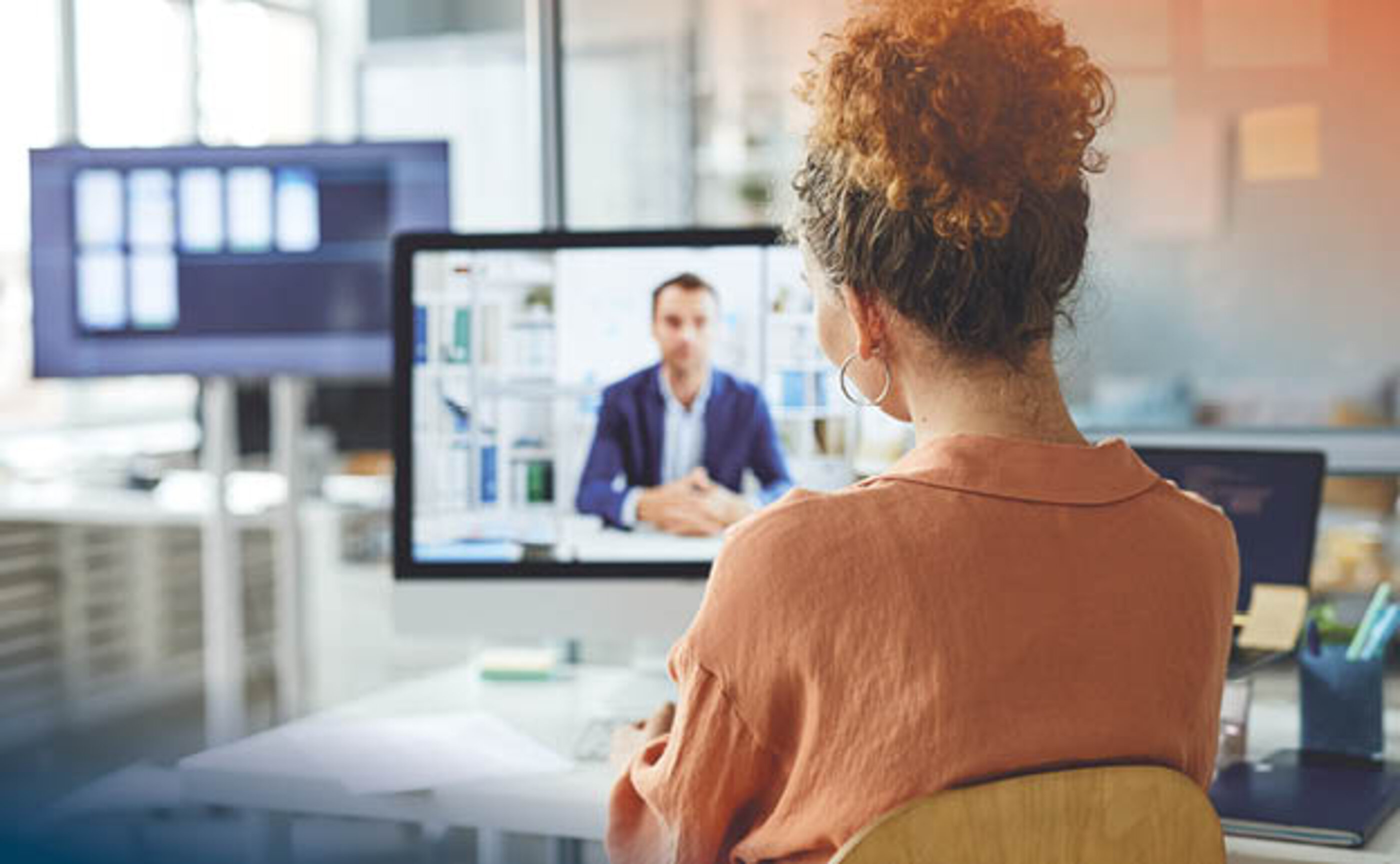 Eine junge Frau sieht auf einen Computerbildschirm
